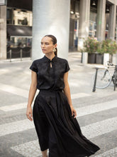 A woman wears a ruched dress